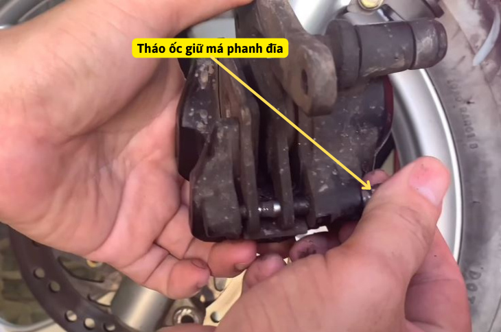 tháo ốc giữ má phanh đĩa